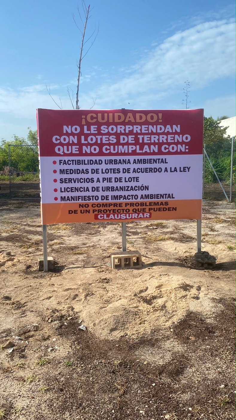 Letrero instalado en un terreno que enumera los permisos que debe tener un lote antes de comprarse.